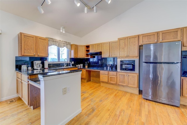 kitchen with open shelves, black oven, light wood finished floors, and freestanding refrigerator