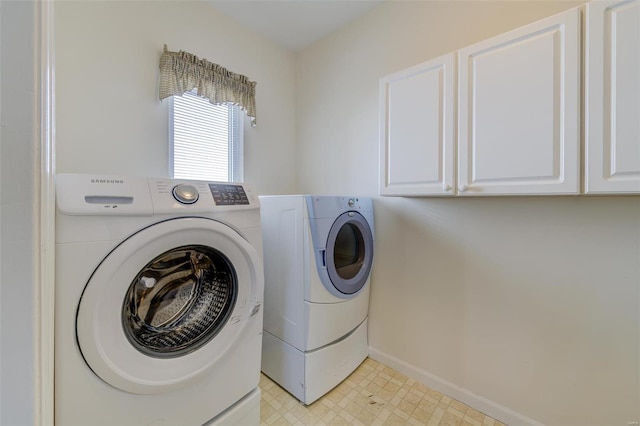 clothes washing area with cabinet space, baseboards, light floors, and separate washer and dryer