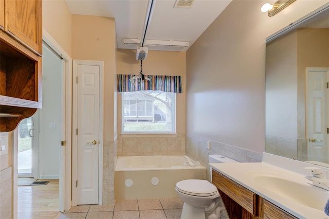 bathroom featuring visible vents, a garden tub, toilet, tile patterned flooring, and vanity