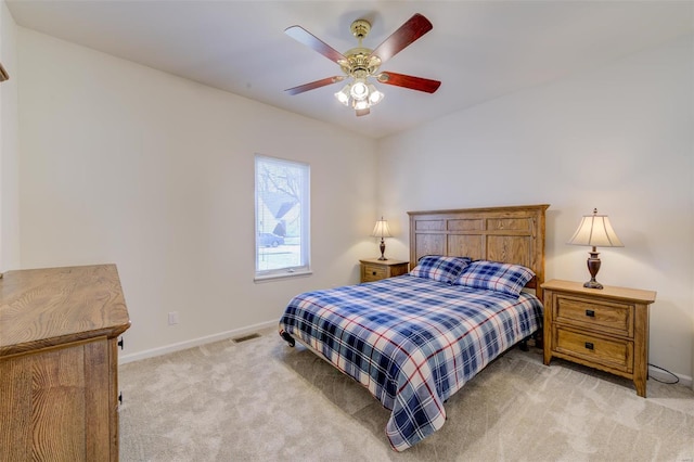 bedroom featuring ceiling fan, light colored carpet, visible vents, and baseboards