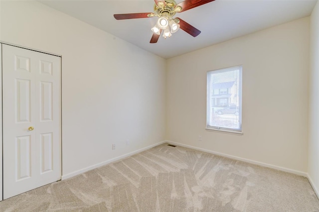 spare room with carpet flooring, baseboards, and ceiling fan