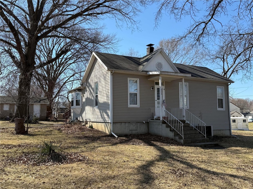 view of front facade featuring crawl space and a chimney