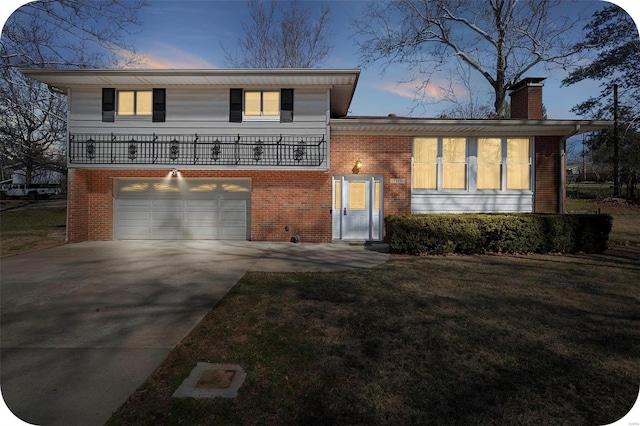 tri-level home with brick siding, driveway, a chimney, and an attached garage