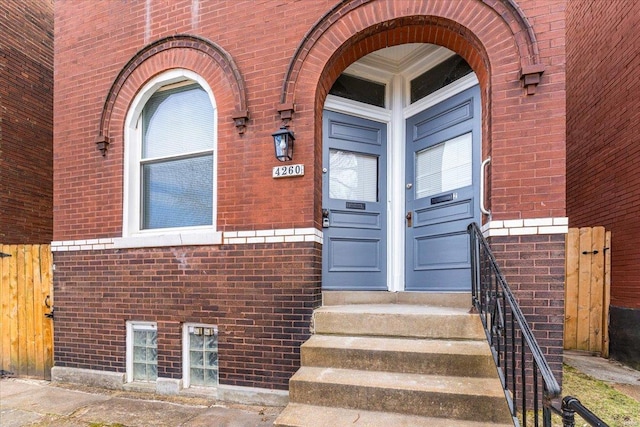 doorway to property featuring brick siding