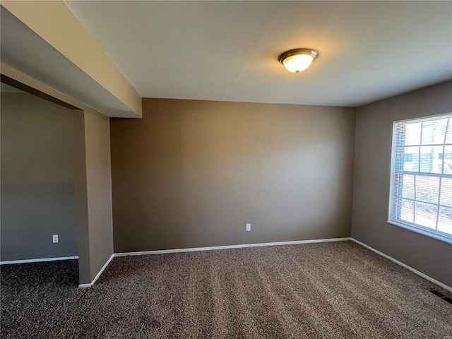 spare room with visible vents, baseboards, and carpet flooring