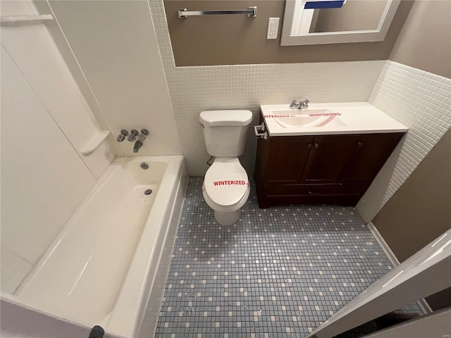 full bathroom with tile patterned floors, toilet, vanity, and tile walls