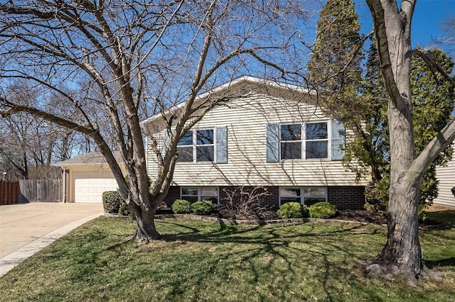 tri-level home featuring a front yard, concrete driveway, fence, and an attached garage