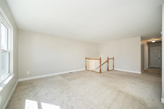 unfurnished room with light colored carpet and baseboards