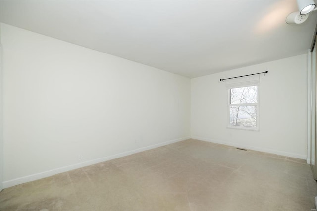 empty room with baseboards and light colored carpet