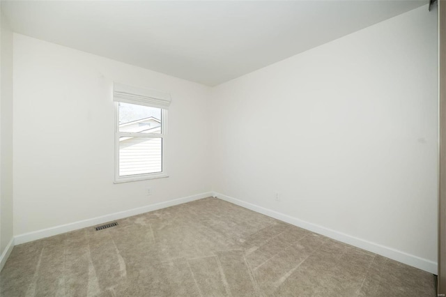 carpeted empty room with visible vents and baseboards