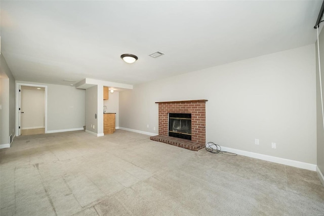 unfurnished living room featuring baseboards, a fireplace, visible vents, and light carpet