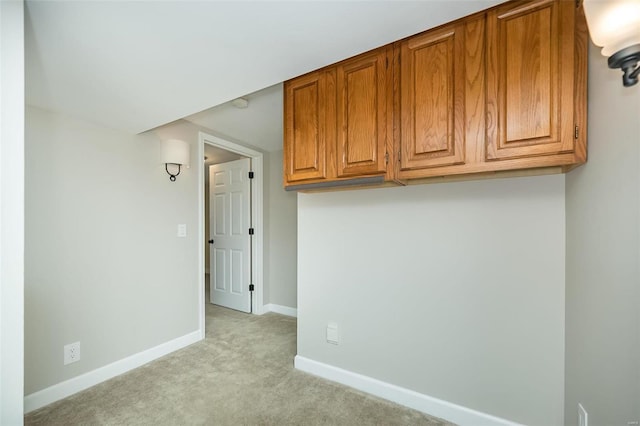 unfurnished room featuring baseboards and light carpet