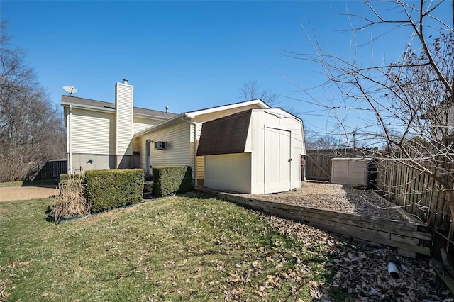 view of side of property with an outbuilding, fence, a shed, a chimney, and a lawn