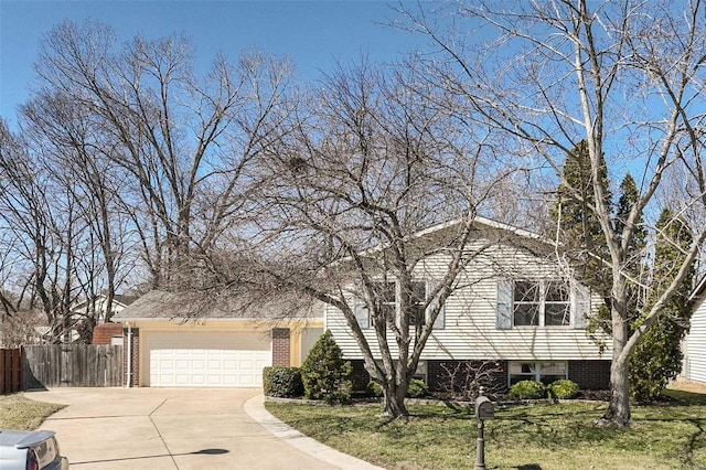 split level home featuring a front yard, fence, driveway, a garage, and brick siding