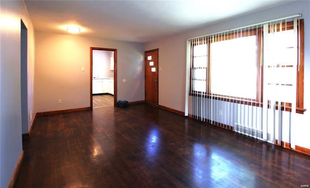 empty room featuring baseboards and wood finished floors