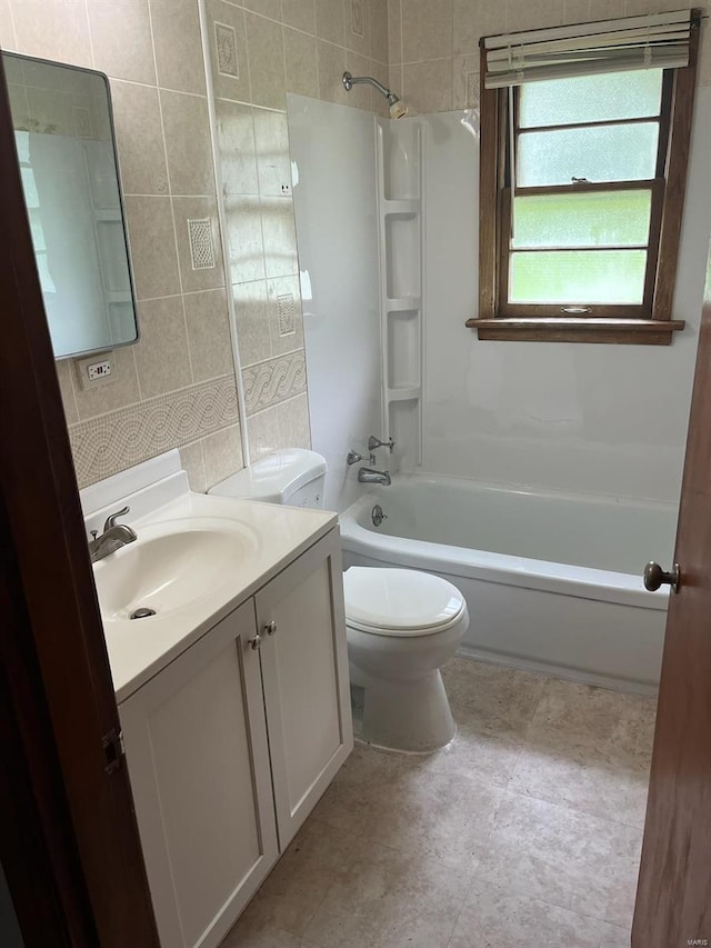 full bath with vanity, tile walls, toilet, and shower / washtub combination