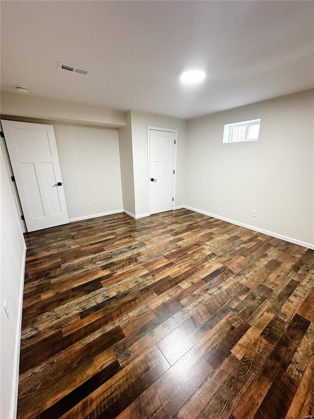 interior space with visible vents, baseboards, and dark wood finished floors