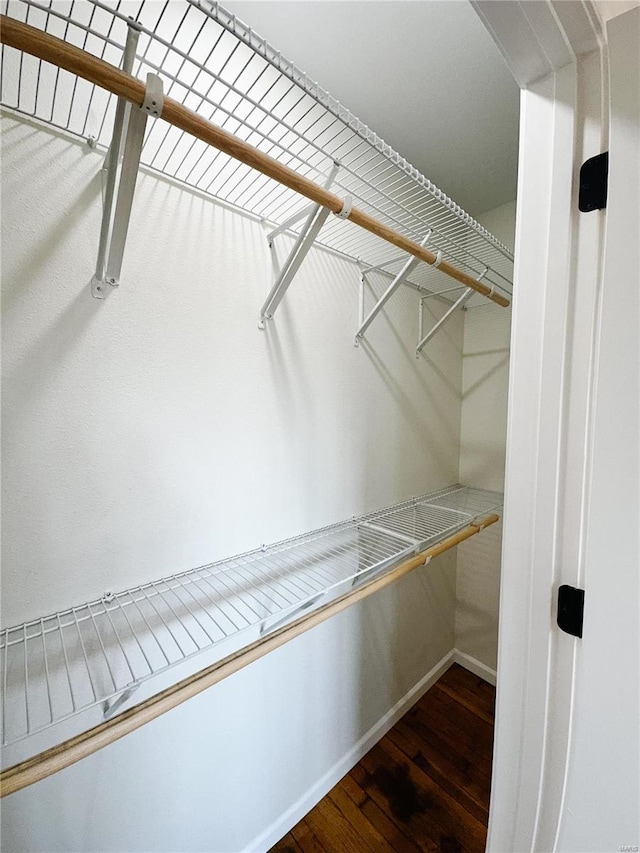 walk in closet with wood finished floors