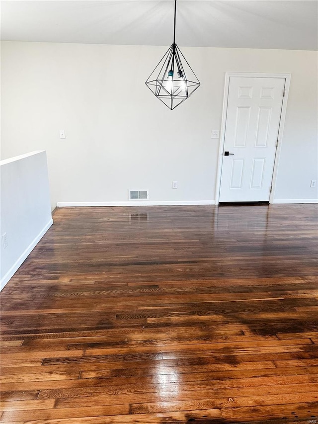 unfurnished dining area featuring visible vents, baseboards, and dark wood finished floors