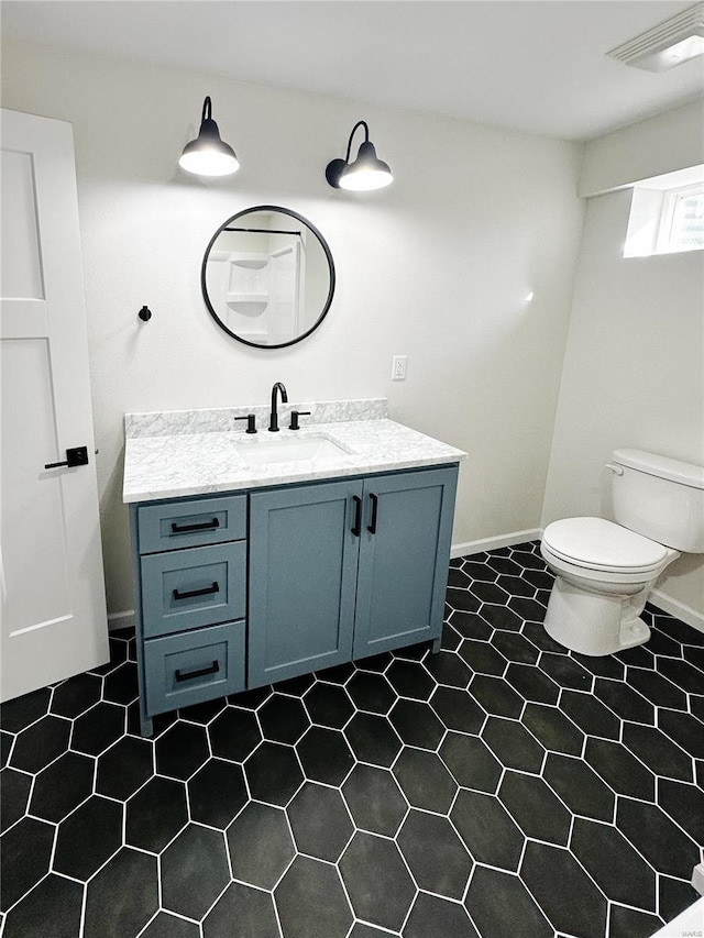 bathroom with vanity, toilet, baseboards, and visible vents