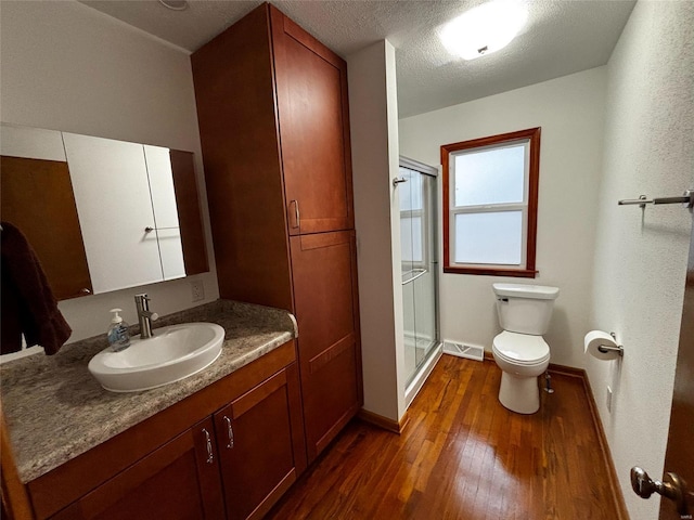 bathroom with visible vents, a stall shower, toilet, and wood-type flooring