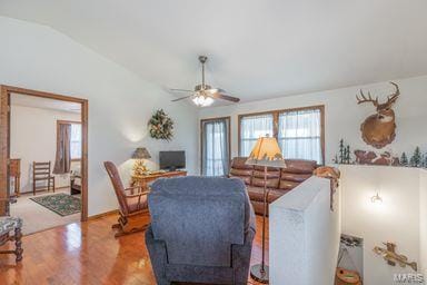 living room featuring a ceiling fan, lofted ceiling, and wood finished floors