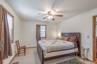 bedroom with ceiling fan, baseboards, and light carpet