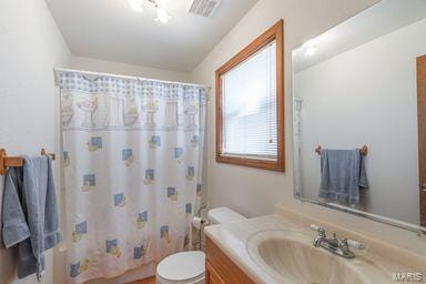 full bath with a shower with shower curtain, visible vents, toilet, and vanity