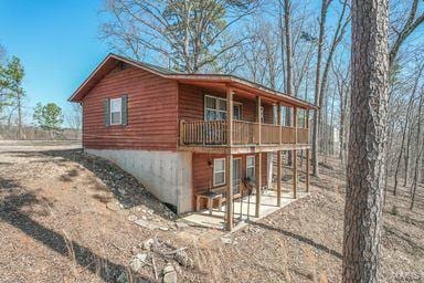 view of home's exterior with log veneer siding and a patio