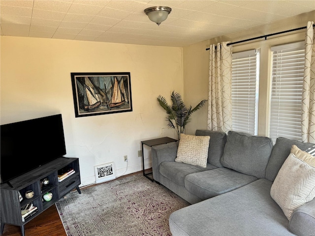 living room featuring visible vents, baseboards, and wood finished floors