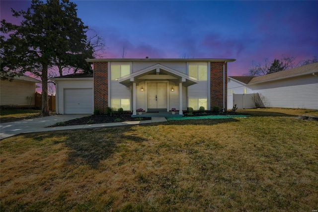 traditional-style home with driveway, a front lawn, a garage, and fence