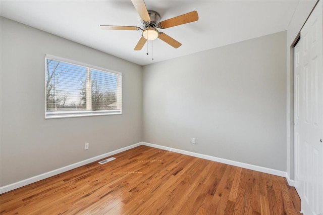 spare room with a ceiling fan, baseboards, visible vents, and light wood finished floors