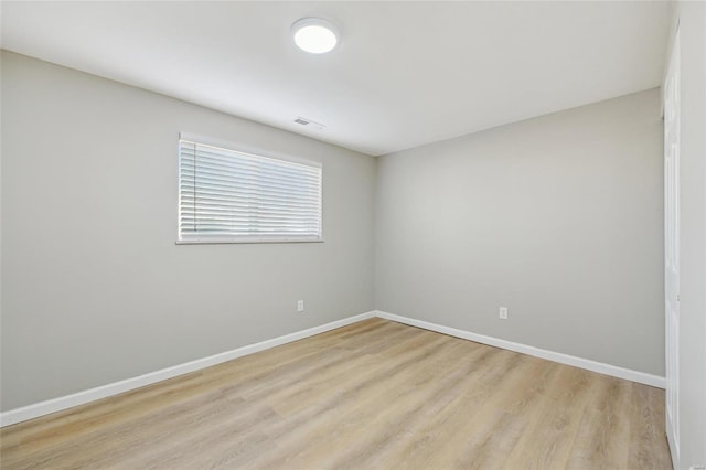 spare room with visible vents, baseboards, and light wood finished floors