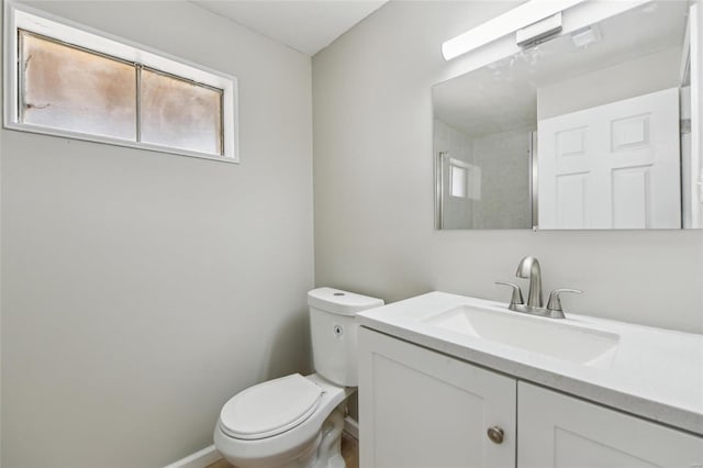 bathroom with vanity, toilet, and baseboards