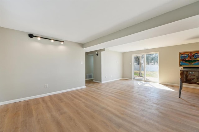 unfurnished living room with visible vents, baseboards, and light wood-type flooring