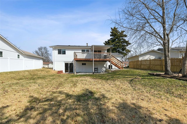 back of house with stairway, a lawn, fence, and a wooden deck