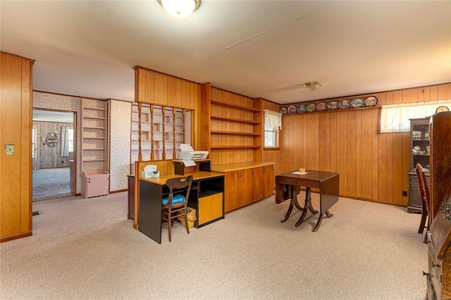 office with baseboards, light colored carpet, and wood walls