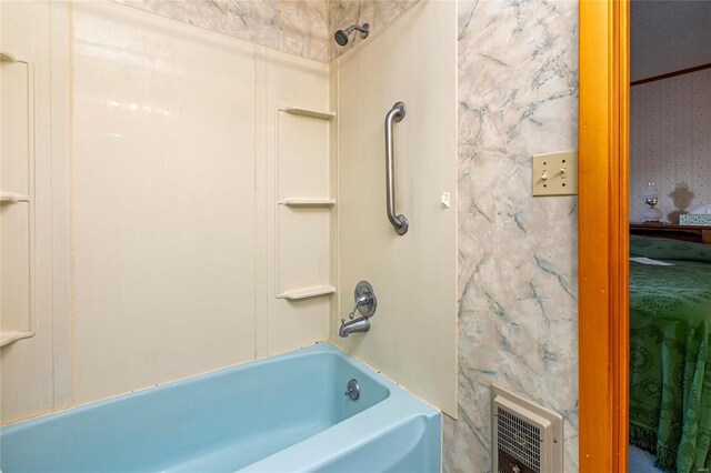 bathroom with wallpapered walls and  shower combination