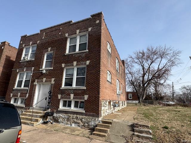 view of front facade with entry steps and brick siding