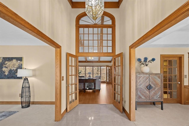 foyer entrance featuring french doors, a high ceiling, and carpet floors