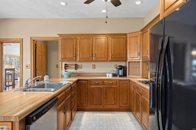 kitchen with a sink, stainless steel dishwasher, freestanding refrigerator, a peninsula, and light countertops