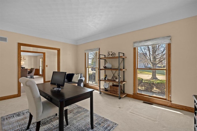 home office with light carpet, plenty of natural light, and visible vents