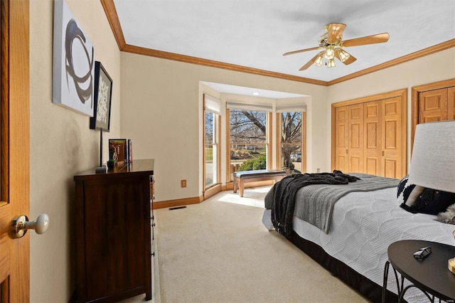 carpeted bedroom with ceiling fan, baseboards, and ornamental molding