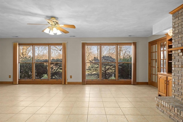 unfurnished living room featuring baseboards, plenty of natural light, and light tile patterned flooring