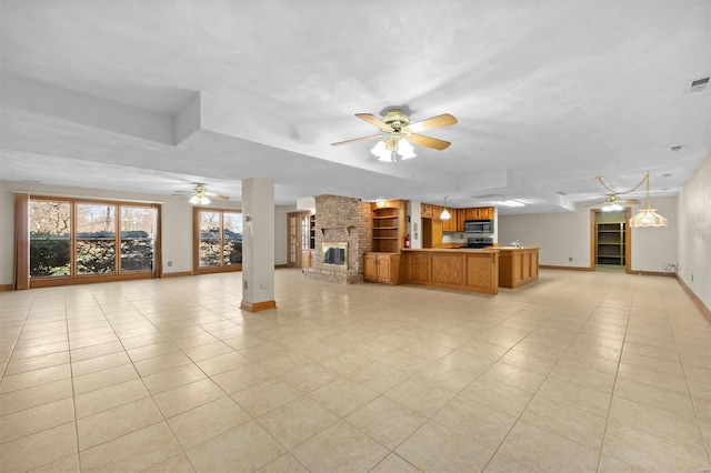 unfurnished living room featuring visible vents, baseboards, light tile patterned flooring, a fireplace, and ceiling fan