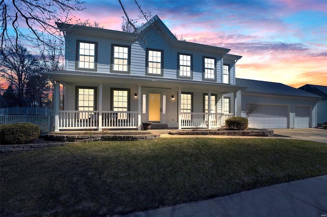 view of front of home featuring a front yard, fence, driveway, a porch, and a garage