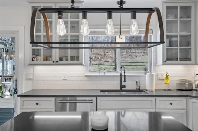 bar featuring a sink, backsplash, and stainless steel dishwasher