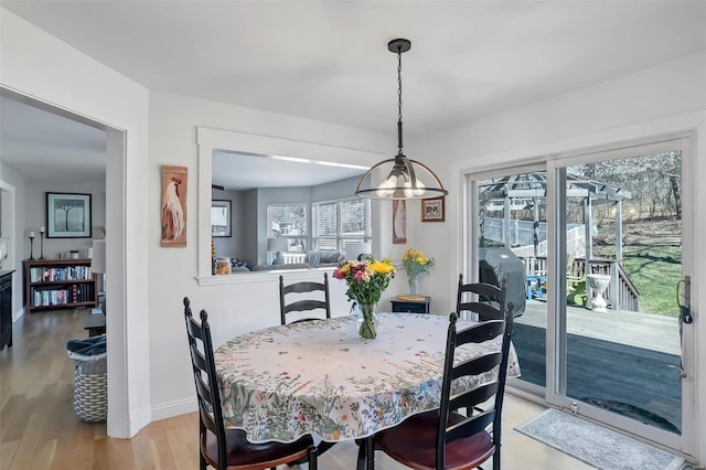 dining room with light wood-type flooring and baseboards