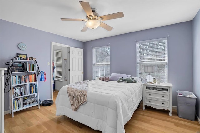 bedroom featuring baseboards, light wood-type flooring, and ceiling fan