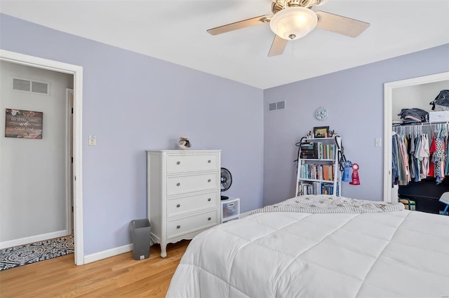 bedroom with visible vents, baseboards, light wood-style floors, and ceiling fan